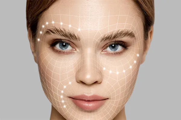 Aesthetic-Fillers-Doctor Close-up of a beautiful face against a gray background, with flowing gridlines illustrated along the cheeks, brow and lips, representing aesthetic filler services from Genifer Chavez, MD in Tucson.