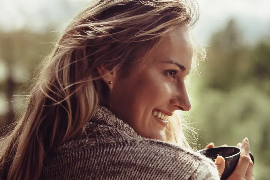 Womens-Health-Clinic A woman in a sweater looks out at the morning forest and smiles. Visit Women's Health expert Genifer Chavez, MD in Tucson.